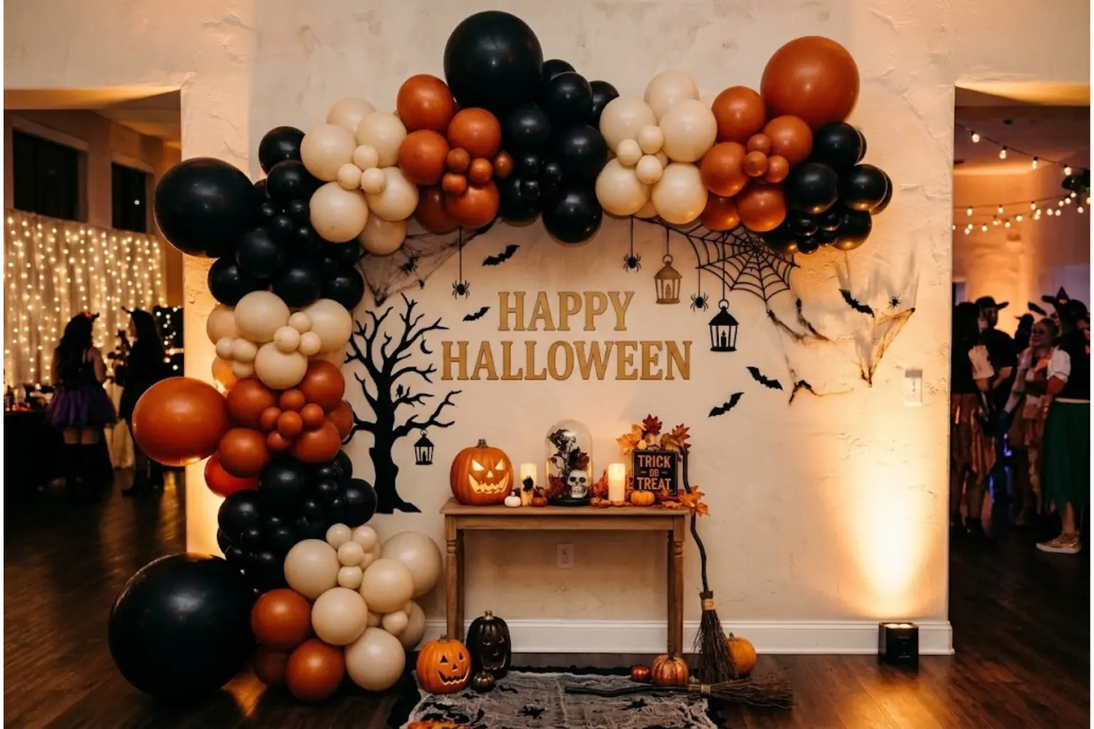 Halloween party backdrop wall ideas with a balloon garland arch, a shadow sheet wall, and a flower wall