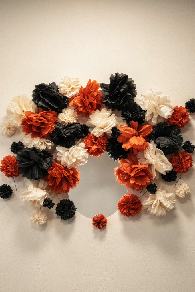 Cloud of black, orange, and cream tissue paper pom-poms covering a bone wall